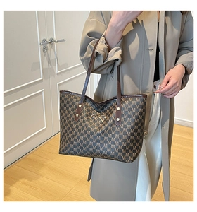 Détail du sac cabas avec motif lettre M et boucle noeud doré en décor intérieur