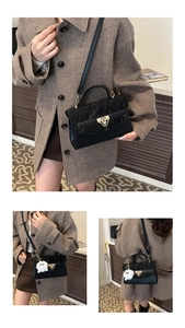 Detail view of contrast stitching handbag featuring gold hardware and chain accents