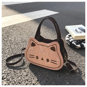 Dettaglio della borsa a tracolla gatto rosa con ricami su sfondo stradale materico