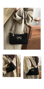 Detail of black leopard print suede shoulder bag with gold bow and floral charm