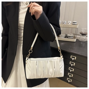 Detailed view of white pleated underarm bag with woven handle and gold metal buckles