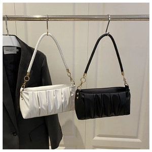 Detail of pleated cloud bags in black and white with woven straps and gold hardware