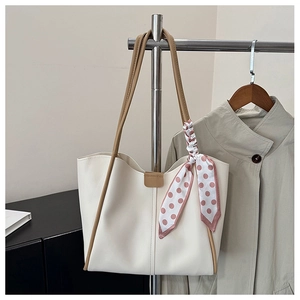 Detail of white PU tote bag featuring a pink polka dot silk scarf on the leather handle