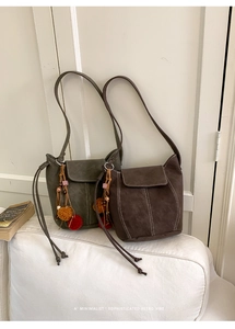 Detailed view of retro bucket bags in olive green and brown with white stitching decoration