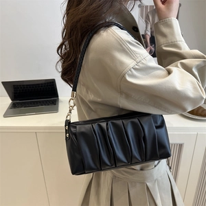 Fashionable black pleated baguette bag with braided shoulder strap and gold hardware