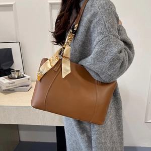 Dark brown tote bag with printed silk scarf shown on shoulder for a stylish casual look