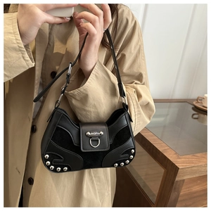 Detail of black crescent shoulder bag with silver studs and mixed leather texture