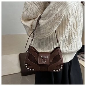 Detail of vintage brown leather hobo bag with silver rivets and metal brand logo