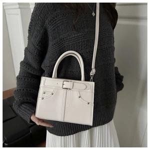 Sac à main en cuir crème minimaliste avec détails de rivets et boucle de ceinture