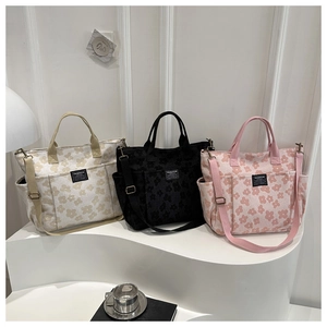 Detailed view of floral tote bags in cream, black, and pink with adjustable shoulder straps