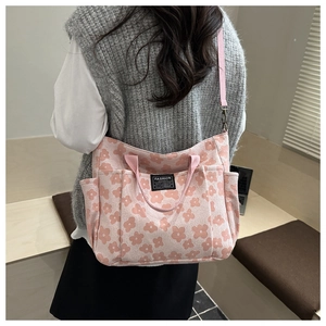 Detail of pink floral canvas tote with adjustable strap and side pocket view