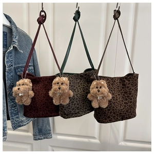 Detailed comparison of leopard print bucket bags in wine red, green, and coffee with bear charm