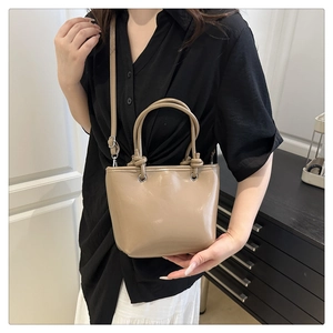 Détail du sac seau café clair avec poignée nouée et bandoulière réglable pratique