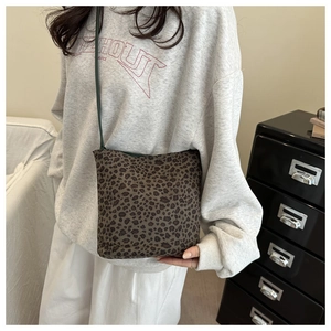Detail of vintage leopard print crossbody bag with green strap and lining on model