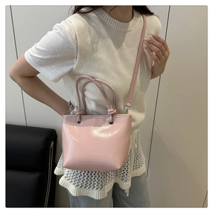 Détail du sac seau rose brillant avec ferrures argentées et bandoulière réglable