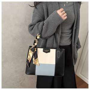 Detail of color-block tote bag with luxury floral silk scarf on the leather handle