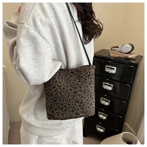Close-up of leopard print suede tote bag with contrast green strap on model