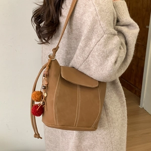 Brown leather bucket shoulder bag for women with ethnic colorful tassel and pompom