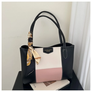 Detail van de kleurgeblokte shopper met zijden sjaal tegen een minimalistische achtergrond