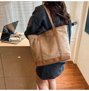 Brown suede tote bag detail featuring large capacity and leather stitching accents