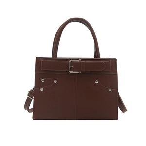 Retro deep brown PU leather handbag with buckle detail and rivets on white background