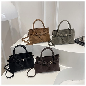 Minimalist matte suede crossbody bags in four colors on a tiered white display