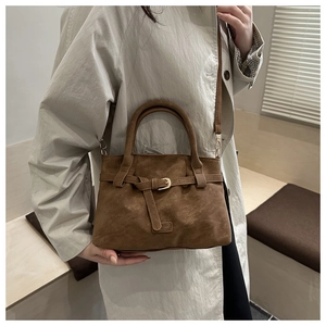 Detail of vintage brown suede tote featuring polished gold buckle and adjustable strap
