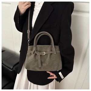 Detail view of the gray suede shoulder bag with adjustable strap and Fashion metal logo