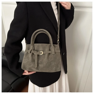 Close-up of minimalist suede tote bag styled with a professional suit for daily use