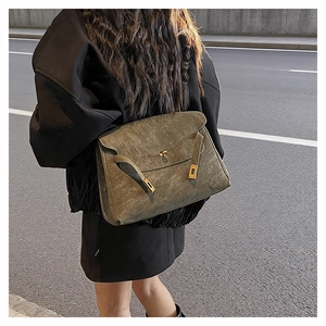 Detail of vintage olive green Kelly bag showing textured finish and metal clasp closure