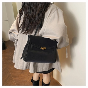 Detail of the black leather bag featuring golden hardware and a classic twist lock