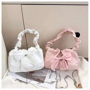 Détail de sacs à main froncés blanc et rose avec grand nœud en résille et chaîne argent