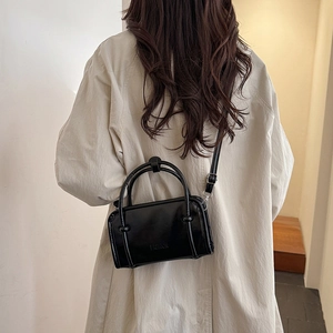 Minimalist black baguette shoulder bag for women with polished finish and fashion logo