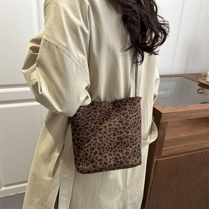 Vintage leopard print suede bucket bag worn cross-body with a stylish trench coat