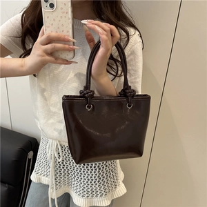 Retro deep brown glossy mini bucket bag with knot handle for women shown in mirror selfie