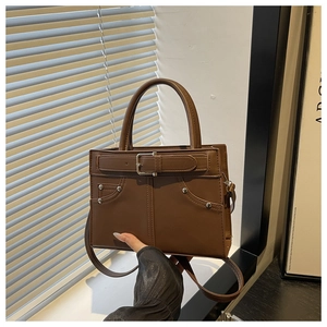 Detail of brown leather handbag with buckle strap and silver studs for casual daily use