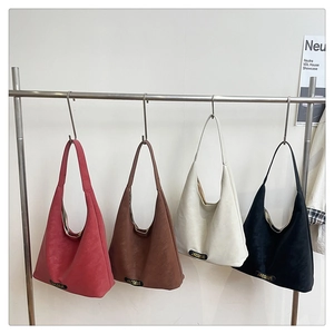 Detailed row of tote bags in red, brown, cream, and black with metallic logo accents