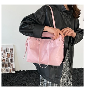 Detailed view of pink tote bag with embossed heart textures and gold hardware details