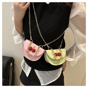 Détail de mini sacs bandoulière rose et vert avec breloques cerise et chaînes dorées