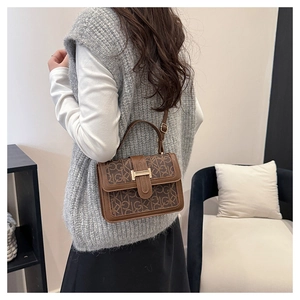 Detail of vintage monogram shoulder bag with gold H-buckle shown on a model