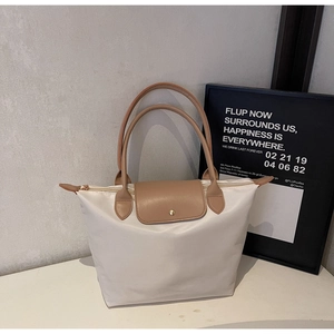 Detail of the high-quality nylon tote with leather flap and round handles in brown