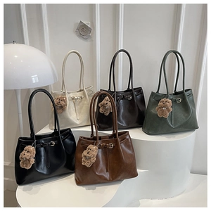 Detailed display of five colorful tote bags with bear charms on minimalist white pedestals