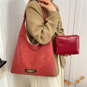 Retro red faux leather tote bag and pouch set styled on a model in a brown blazer