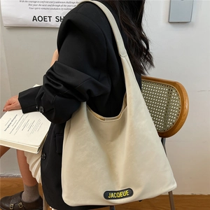 Minimalist beige hobo tote bag in soft leather styled with a black blazer outfit