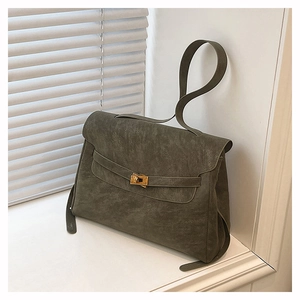 Detail of vintage textured olive green tote bag with gold twist lock on a white window sill