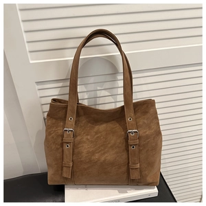 Détail du grand sac cabas en similicuir marron avec lanières à boucles métalliques