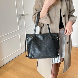 Chic black embossed large tote bag for women with gold hardware shown on a model