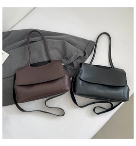 Flat lay detail of minimalist tote bags in dark brown and black leather with flap closure