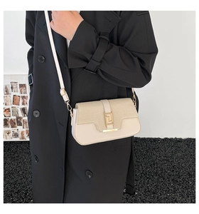 Detail of elegant cream faux leather crossbody bag with chic woven texture and gold clasp