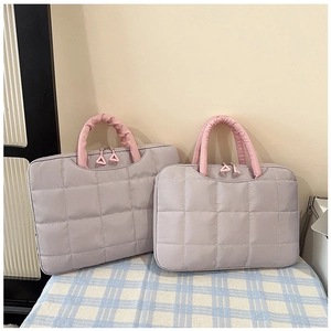 Detail of lavender quilted laptop bags with pink ruffled handles and metal zippers